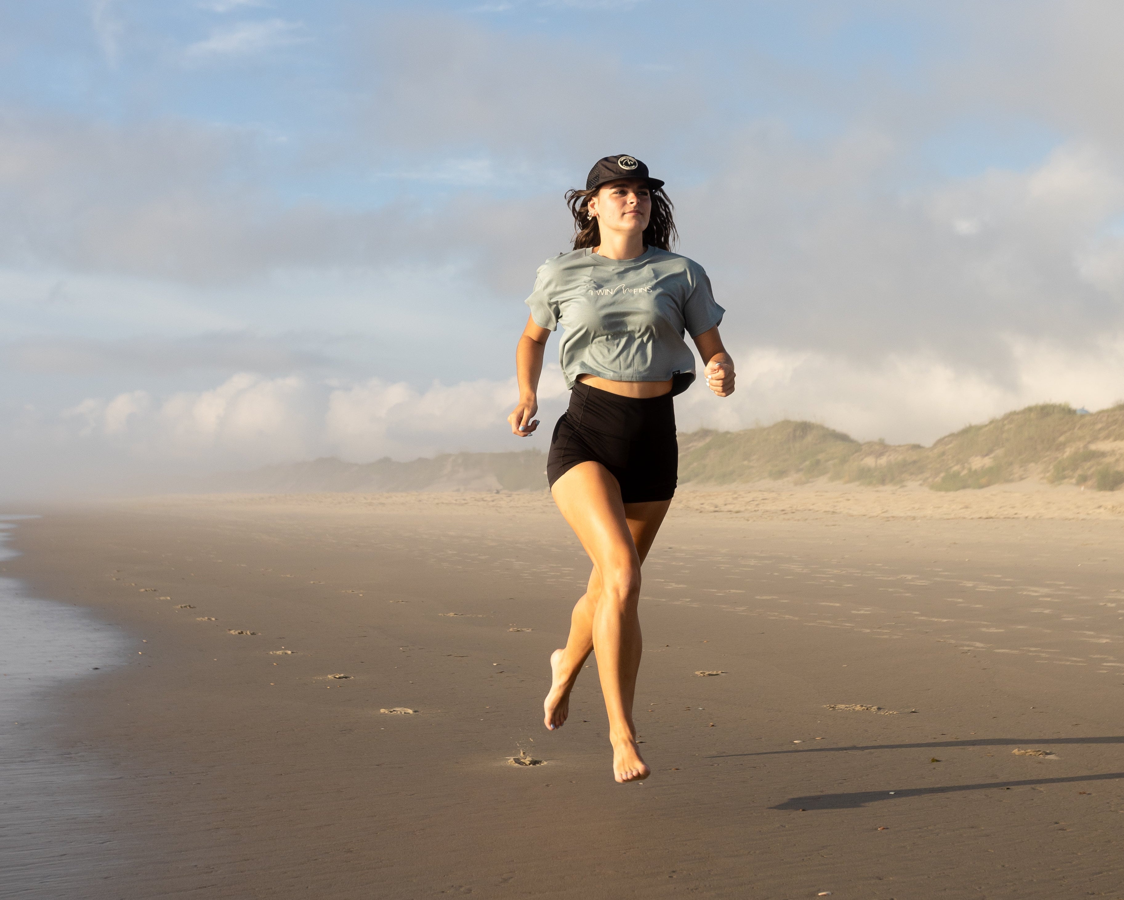 Person walking on a beach with a clear sky